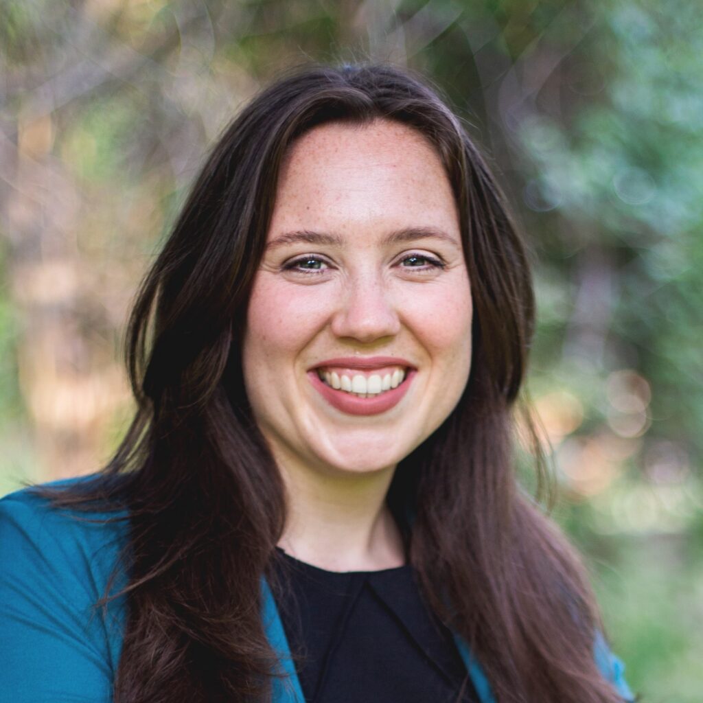 Headshot of Hannah Debelius in front of a nature background.
